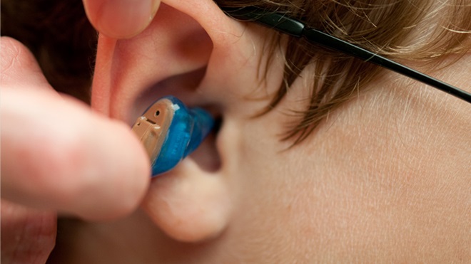 close-up of a boy having hearing aid fitted